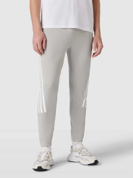Zdjęcie produktu Spodnie dresowe z paskami w kontrastowym kolorze Adidas
