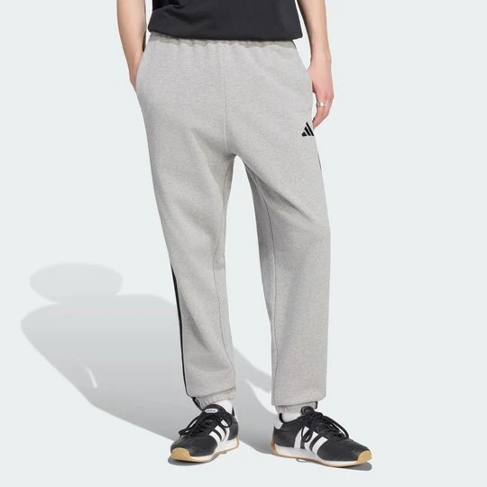 Zdjęcie produktu Spodnie Essentials z tkaniny frotté z 3 paskami i zwężanymi nogawkami Adidas