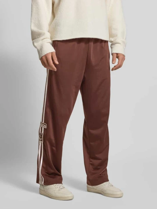 Zdjęcie produktu Spodnie sportowe o szerokim kroju z wyhaftowanym logo model ‘Adibreak’ adidas Originals Ciemnobrązowy