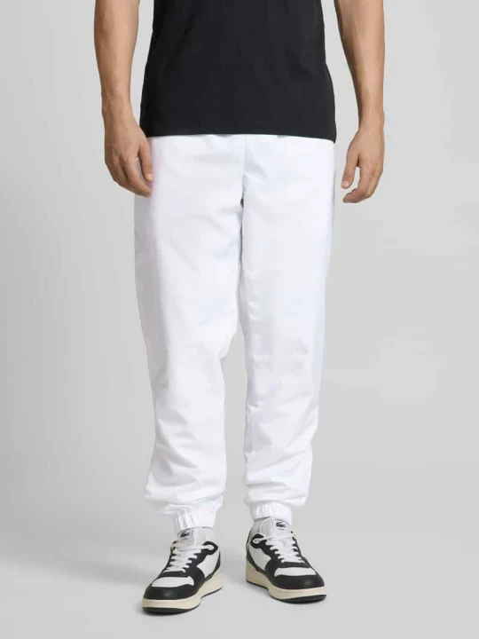 Zdjęcie produktu Spodnie dresowe o kroju relaxed fit z naszywką z logo Lacoste Biały