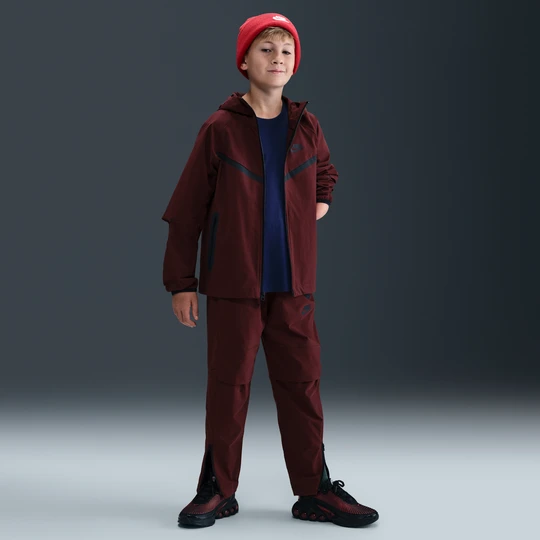 Zdjęcie produktu Spodnie z tkaniny dla dużych dzieci (chłopców) Nike Tech - Czerwony