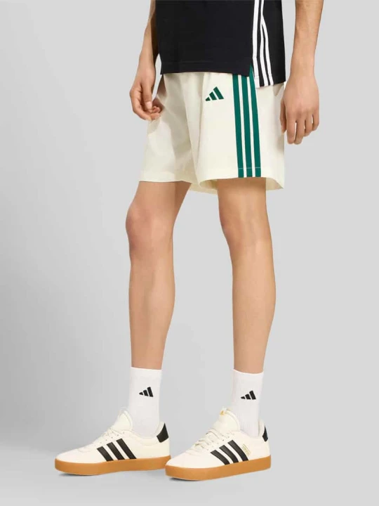 Zdjęcie produktu Szorty dresowe o kroju regular fit z rozcięciem z boku Adidas Złamany biały