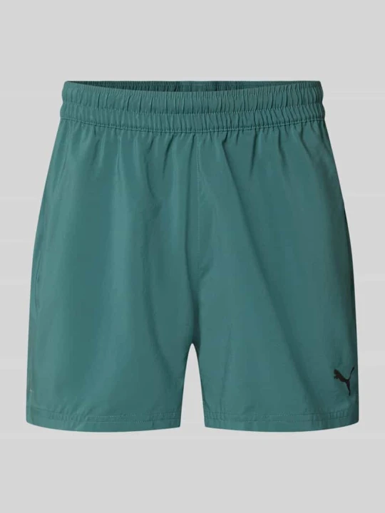 Zdjęcie produktu Szorty sportowe o kroju regular fit z nadrukiem z logo model „TAD ESSENTIALS” Puma Ciemnozielony