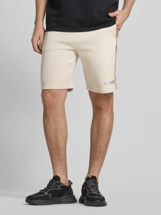 Zdjęcie produktu Szorty z dzianiny dresowej o kroju regular fit z nadrukiem z logo model ‘MICKEY’ Guess Beżowy