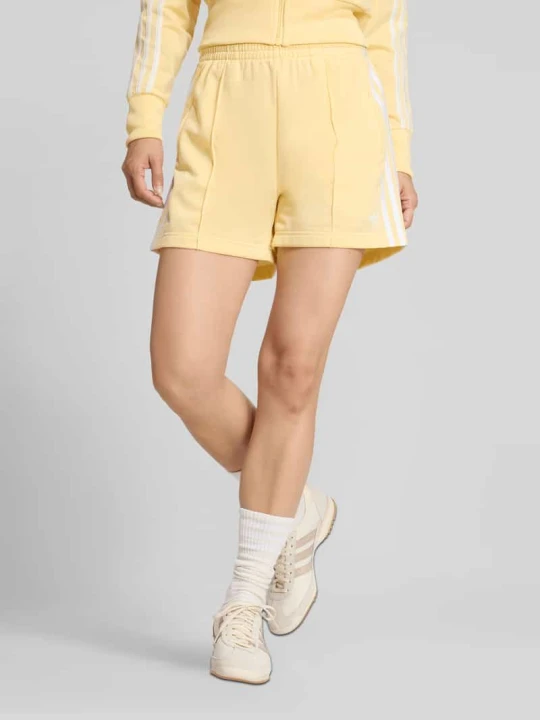 Zdjęcie produktu Szorty z wyhaftowanym logo model 'FIREBIRD CLASSIC' adidas Originals Jasnożółty