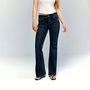 Niebieskie jeansy bootcut z niskim stanem i klapkami na kieszeniach House granatowy