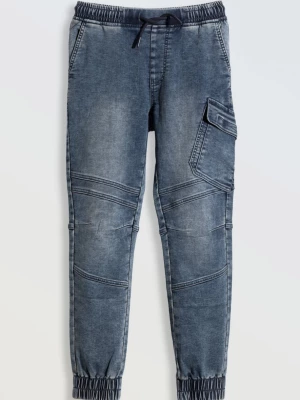 Niebieskie spodnie jeansowe typu joggery z modnymi przeszyciami