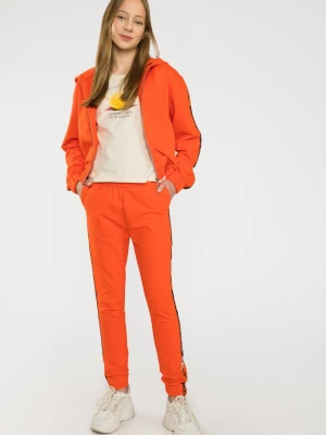 Pomarańczowe spodnie dresowe z ozdobnymi lampasami