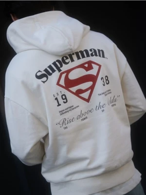 Reserved - Bawełniana bluza z kapturem SUPERMAN™ - złamana biel