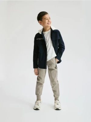 Reserved - Bawełniane spodnie jogger - beżowy