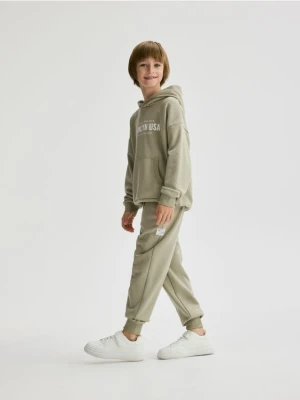 Reserved - Bawełniane spodnie jogger - jasnozielony