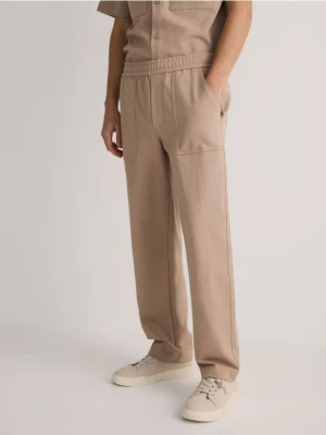 Reserved - Spodnie comfort fit - beżowy