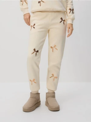 Reserved - Spodnie dresowe z aplikacjami - złamana biel