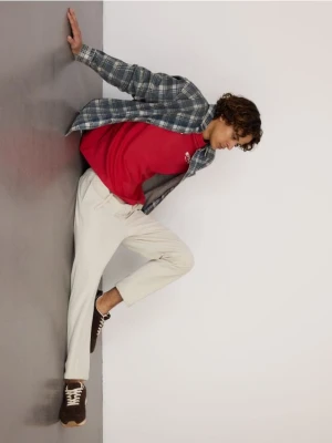 Reserved - Sztruksowe spodnie jogger - złamana biel