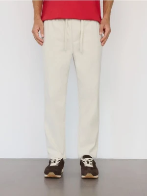 Reserved - Sztruksowe spodnie jogger - złamana biel