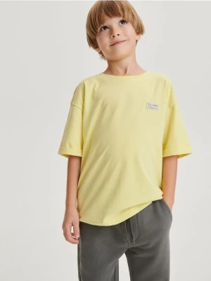 Reserved - T-shirt oversize z naszywką - żółty