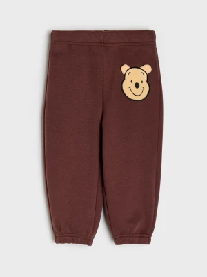 Sinsay - Bawełniane spodnie dresowe jogger z ociepleniem Winnie the Pooh - brązowy