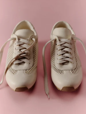 Skórzane kremowe sneakersy z ozdobnymi przywieszkami TARANKO