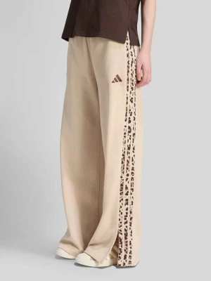 Spodnie dresowe o kroju loose fit z mieszanki bawełny Adidas Piaskowy