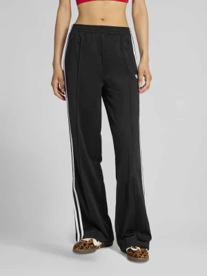 Spodnie dresowe o kroju loose fit z paskami w kontrastowym kolorze adidas Originals