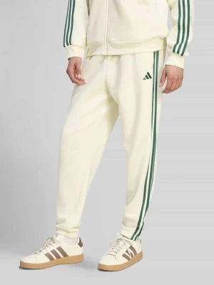 Spodnie dresowe o kroju regular fit z mieszanki bawełny Adidas Złamany biały