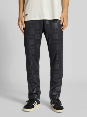 Spodnie dresowe o kroju regular fit z nadrukiem logo na całej powierzchni model ‘Reg’ adidas Originals