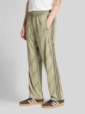 Spodnie dresowe o kroju regular fit z nadrukiem z logo na całej powierzchni adidas Originals Srebrny