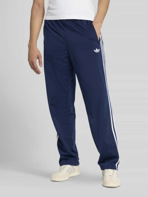 Spodnie dresowe o kroju regular fit z paskami w kontrastowym kolorze model 'FIREBIRD TP' adidas Originals