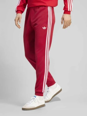 Spodnie dresowe o kroju slim fit z domieszką bawełny adidas Originals Bordowy
