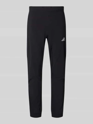 Spodnie dresowe o kroju slim fit z nadrukiem z logo Adidas Training