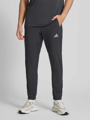 Spodnie dresowe o kroju slim fit z nadrukiem z logo adidas Training