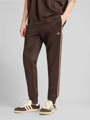 Spodnie dresowe o kroju slim fit z wyhaftowanym logo adidas Originals Ciemnobrązowy