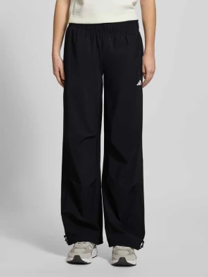 Spodnie materiałowe o kroju wide fit z nadrukiem z logo adidas Sportswear