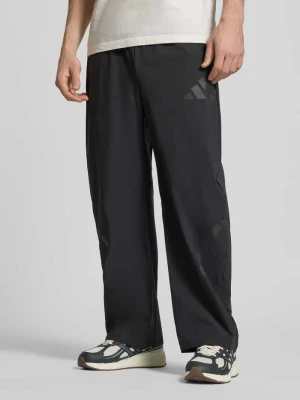 Spodnie sportowe o kroju oversized z kieszeniami zapinanymi na zamek błyskawiczny adidas Sportswear