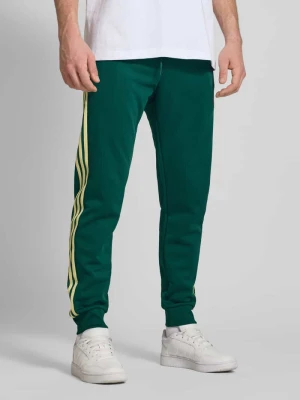 Spodnie treningowe o kroju regular fit z charakterystycznymi dla marki paskami adidas Originals