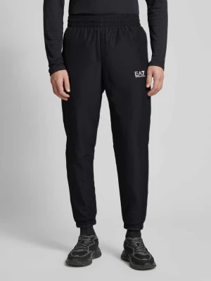 Spodnie typu track pants o kroju tapered fit z nadrukiem z logo EA7 Emporio Armani