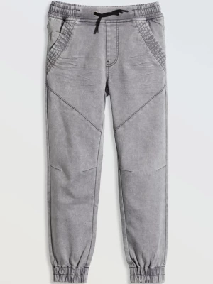 Szare spodnie jeansowe typu joggery z modnymi przeszyciami